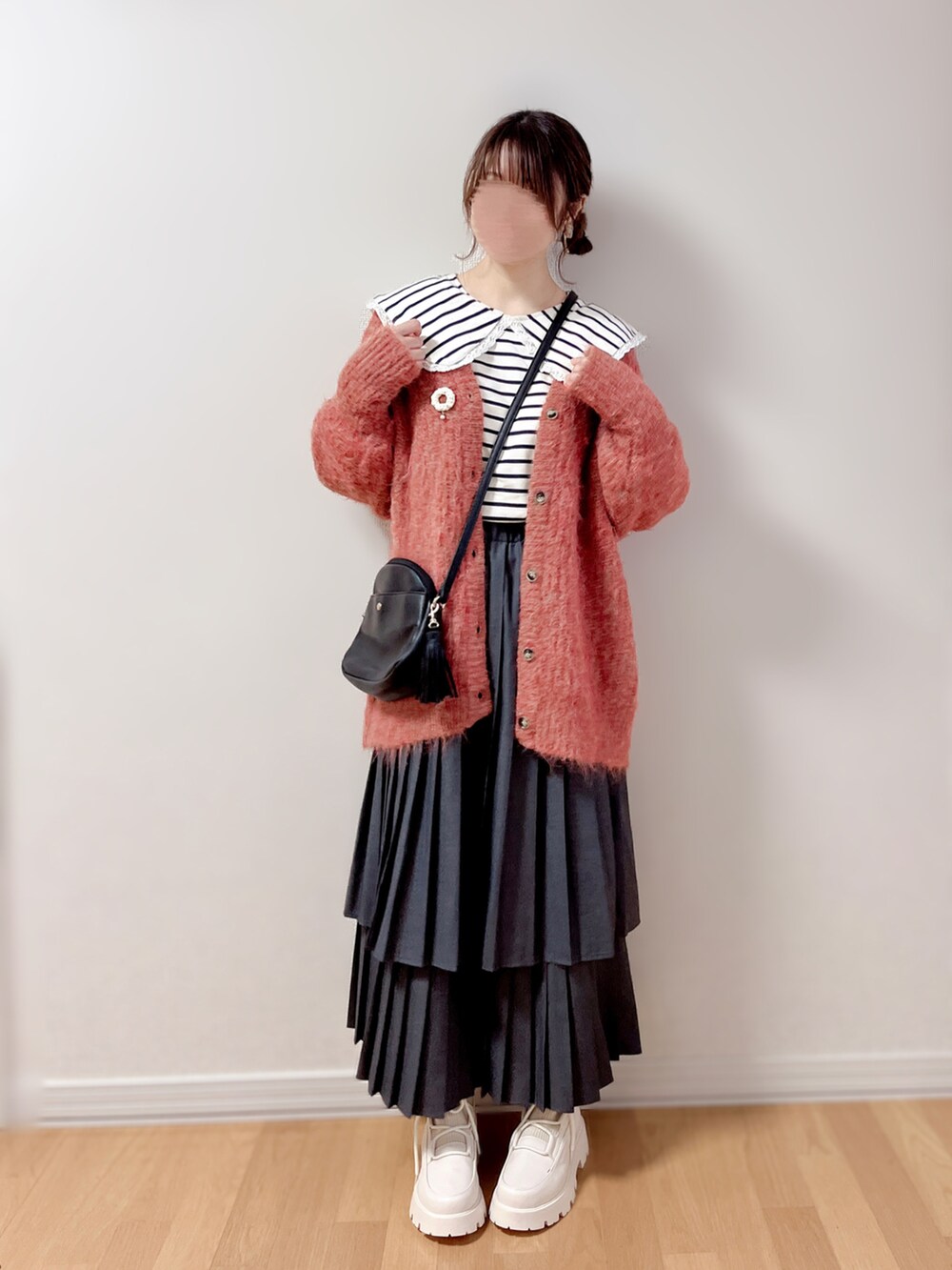 ブラック系のショルダーバッグ、ホワイト系のブローチ/コサージュを着用したレディースの冬コーディネートの2枚目の写真