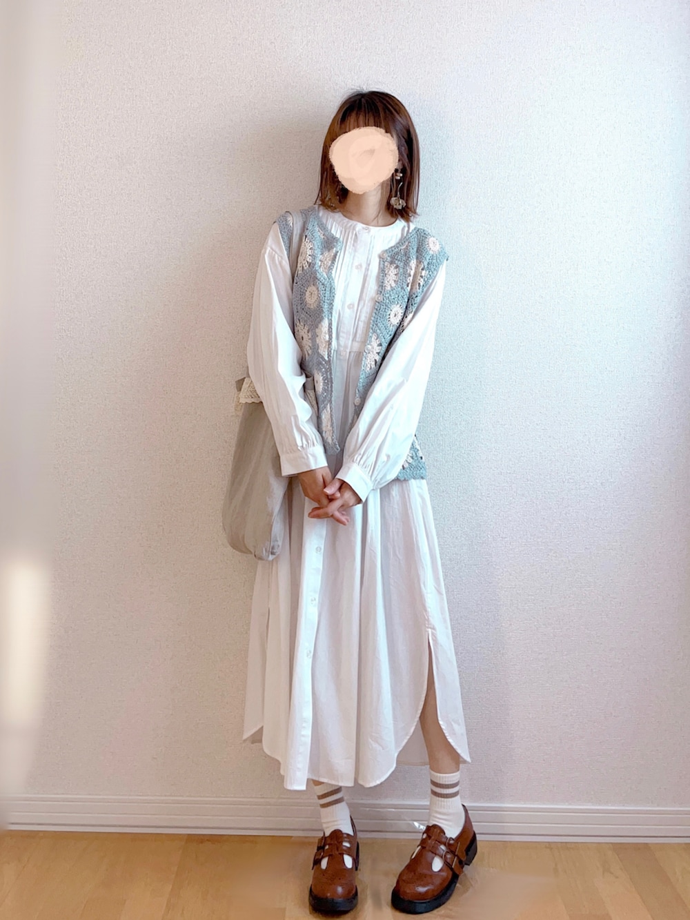 グレー系のベスト、ホワイト系のワンピース、イエロー系のバックパック/リュックを着用したレディースの秋コーディネートの2枚目の写真