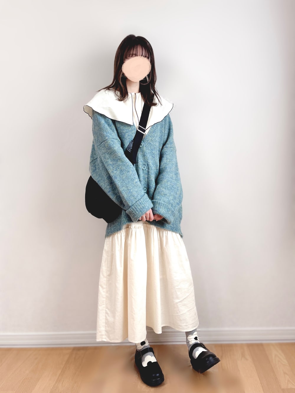 ホワイト系のワンピース、グリーン系のカーディガン/ボレロ、ブラック系のショルダーバッグを着用したレディースの秋コーディネートの4枚目の写真