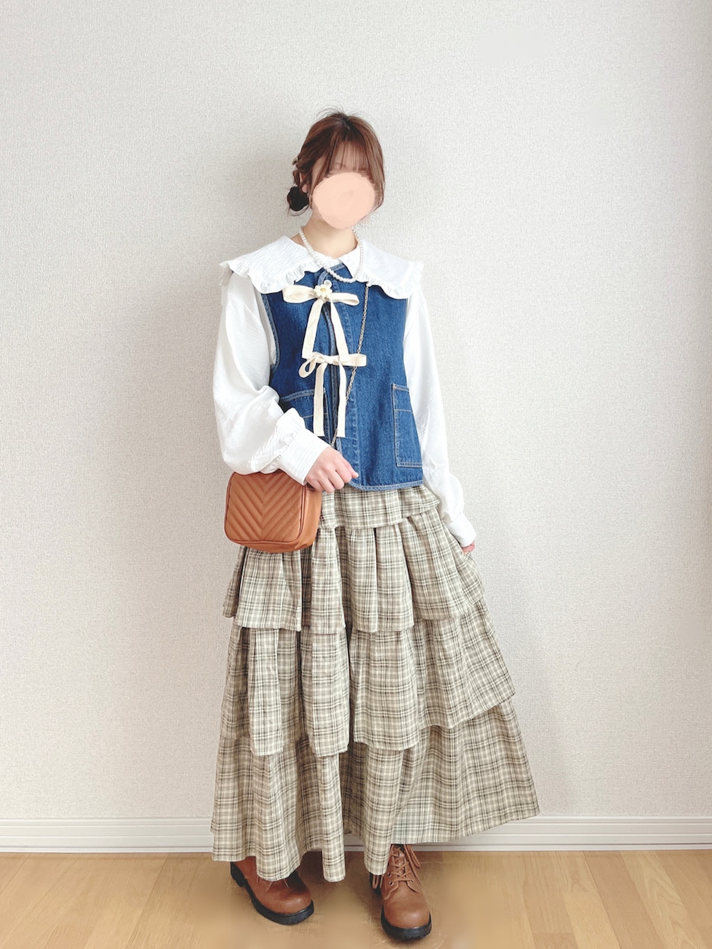 ブルー系のベスト、ホワイト系のシャツ/ブラウス、グリーン系のスカートを着用したレディースの夏コーディネートの3枚目の写真