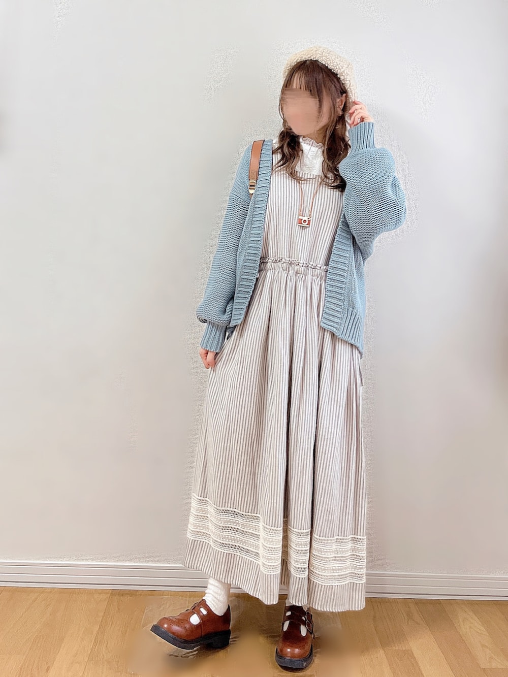 ブルー系のカーディガン/ボレロ、グレー系のジャンパースカート、ホワイト系のシャツ/ブラウスを着用したレディースの秋コーディネートの2枚目の写真