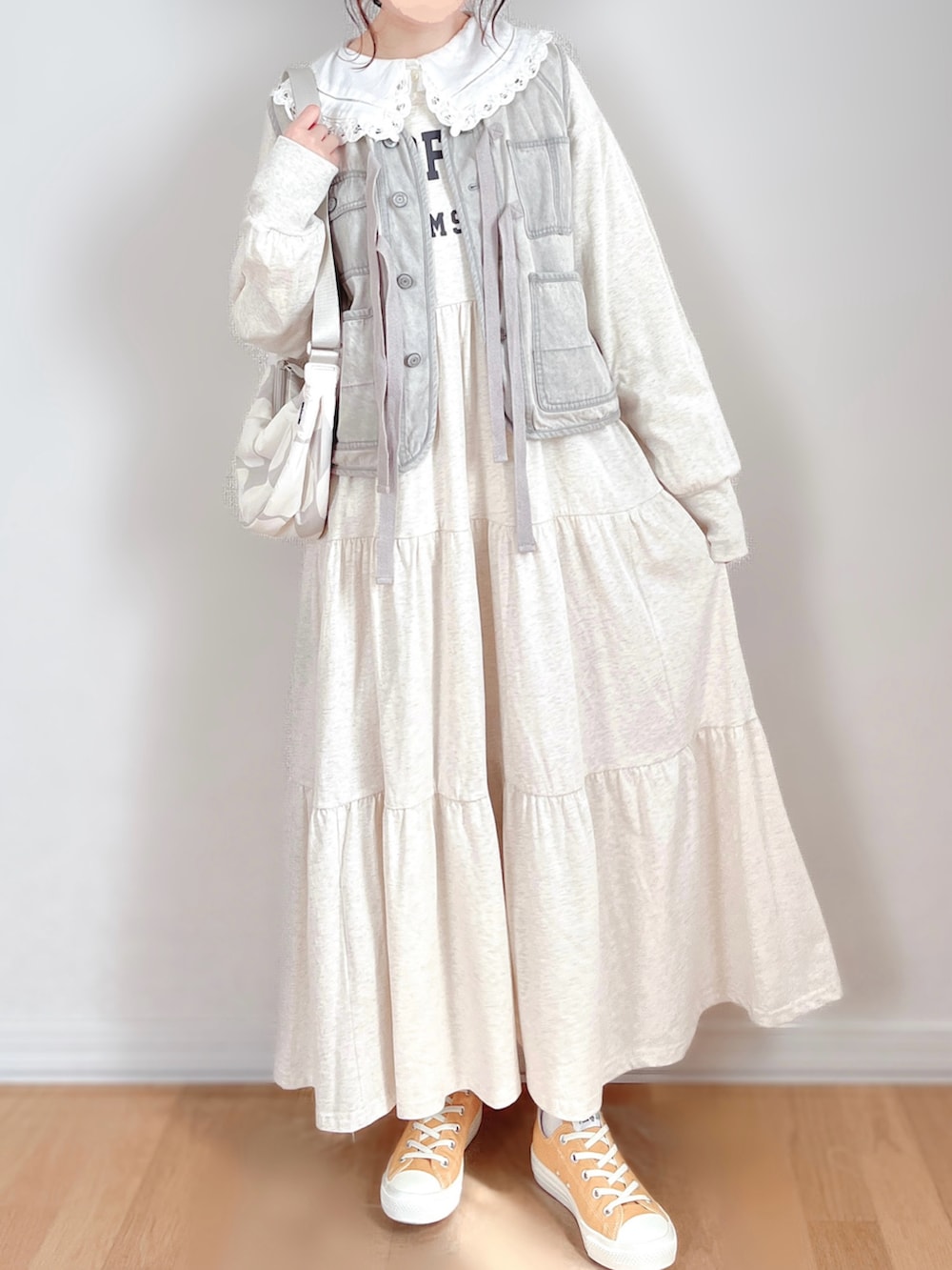 グレー系のベスト、ベージュ系のワンピース、ホワイト系のシャツ/ブラウスを着用したレディースの春コーディネートの4枚目の写真