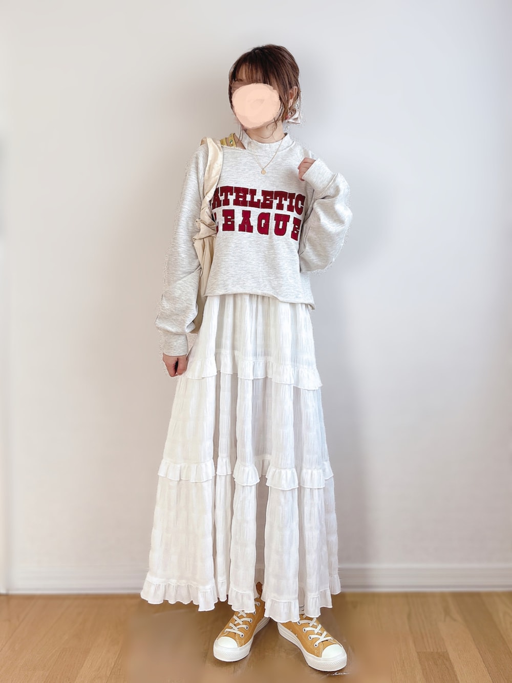 グレー系のスウェット、ホワイト系のワンピース、ゴールド系のスニーカーを着用したレディースの春コーディネートの3枚目の写真