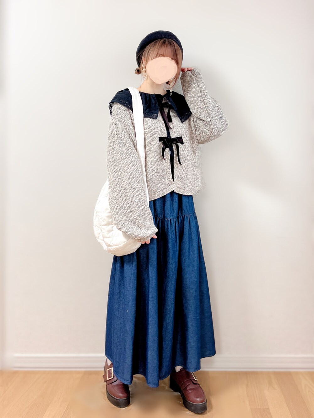 ブルー系のスカート、ベージュ系のショルダーバッグ、ブラウン系のローファーを着用したレディースの秋コーディネートの3枚目の写真