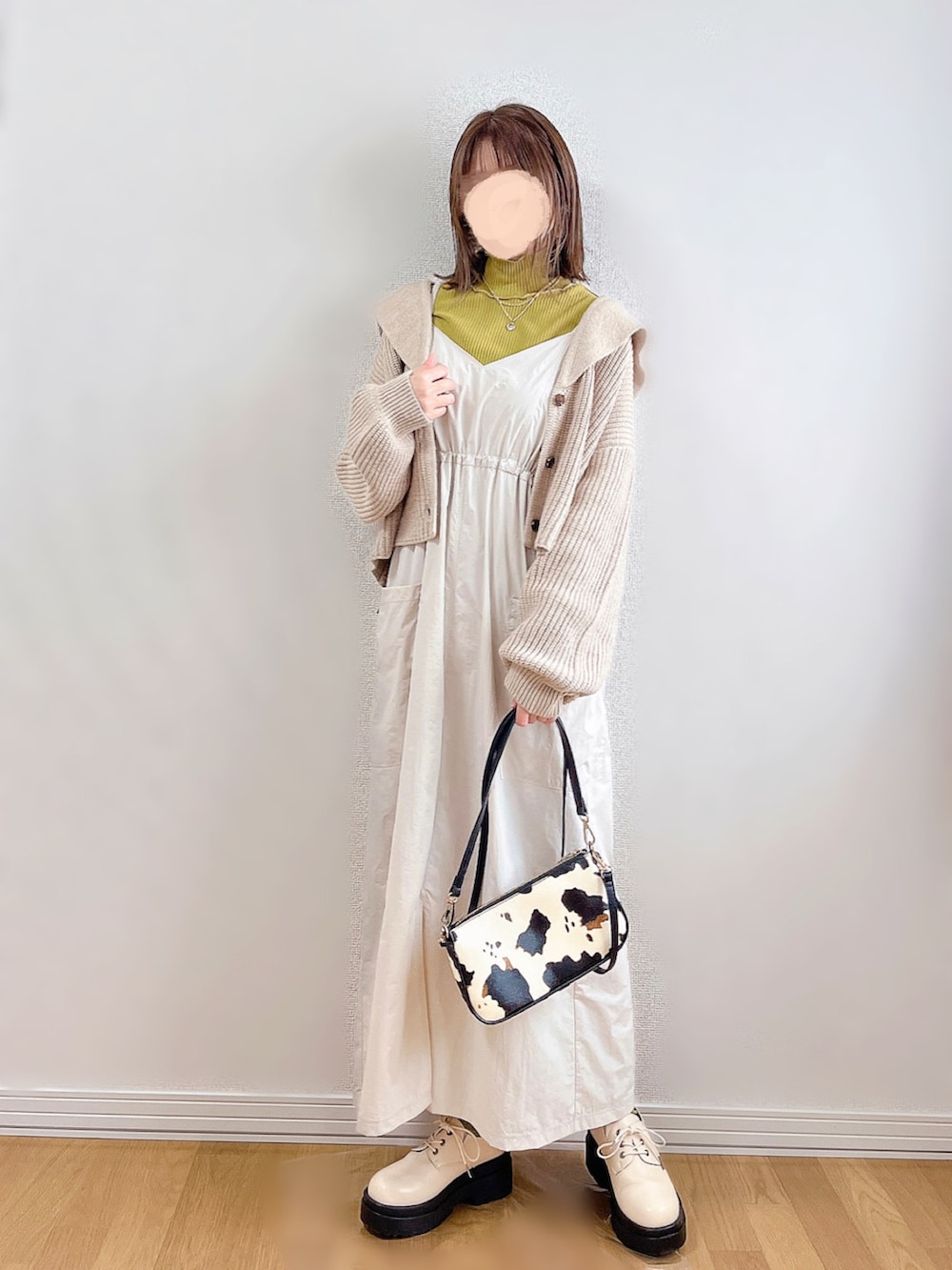 ホワイト系のワンピース、ベージュ系のカーディガン/ボレロ、イエロー系のTシャツ/カットソーを着用したレディースの冬コーディネートの2枚目の写真