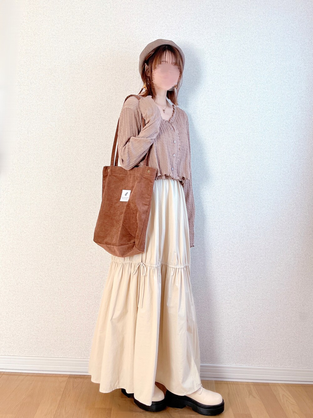 ブラウン系のカーディガン/ボレロ、ホワイト系のスカート、ブラウン系のトートバッグを着用したレディースの秋コーディネートの4枚目の写真