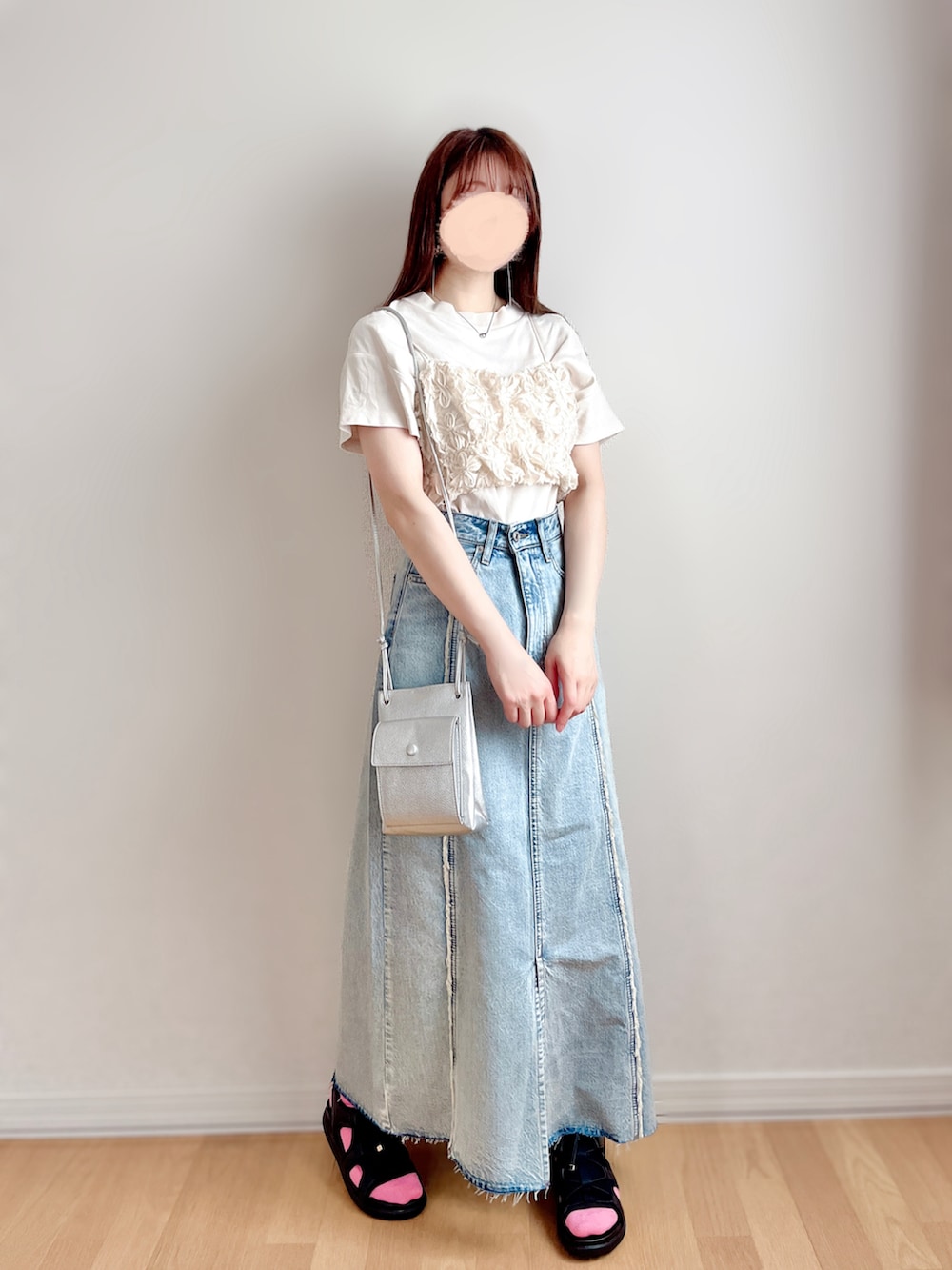 ホワイト系のベスト、ブルー系のスカート、ブラック系のサンダルを着用したレディースの夏コーディネートの3枚目の写真