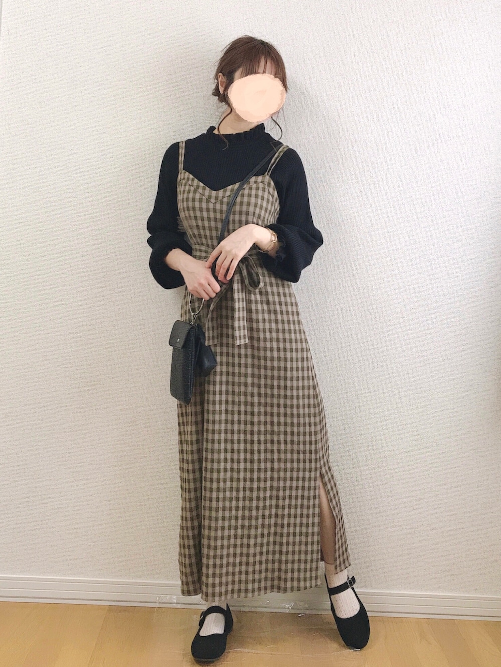 グリーン系のワンピース、ブラウン系のニット/セーター、ブラック系のショルダーバッグを着用したレディースの春コーディネートの2枚目の写真