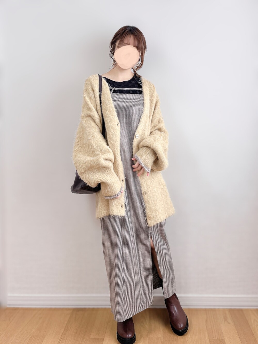 イエロー系のカーディガン/ボレロ、ブラウン系のワンピース、ブラック系のTシャツ/カットソーを着用したレディースの冬コーディネートの3枚目の写真