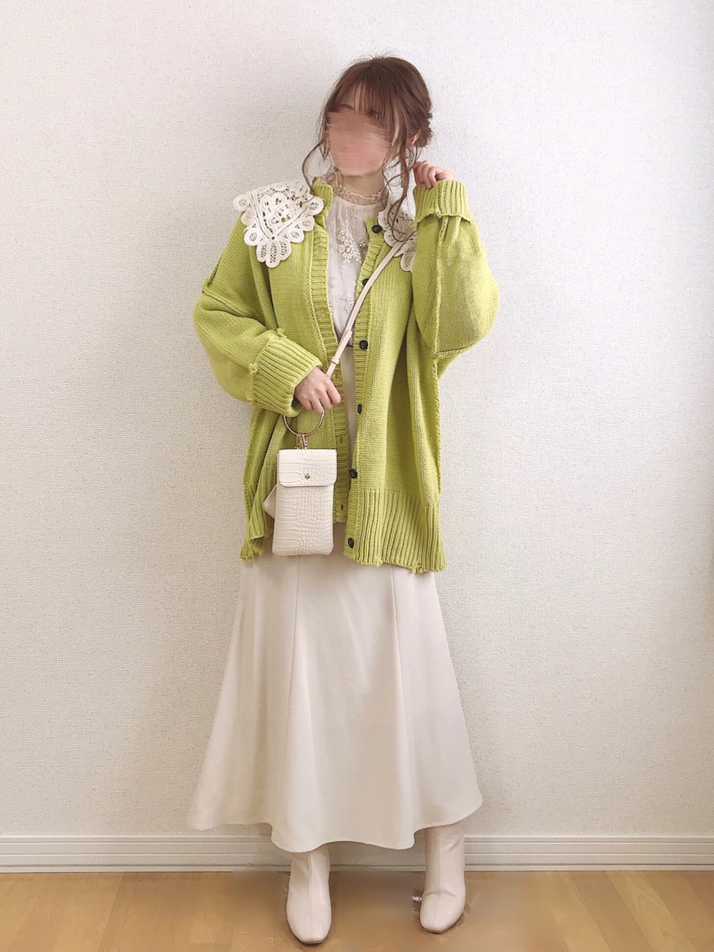 イエロー系のカーディガン/ボレロ、ホワイト系のシャツ/ブラウス、ホワイト系のスカートを着用したレディースの春コーディネートの2枚目の写真