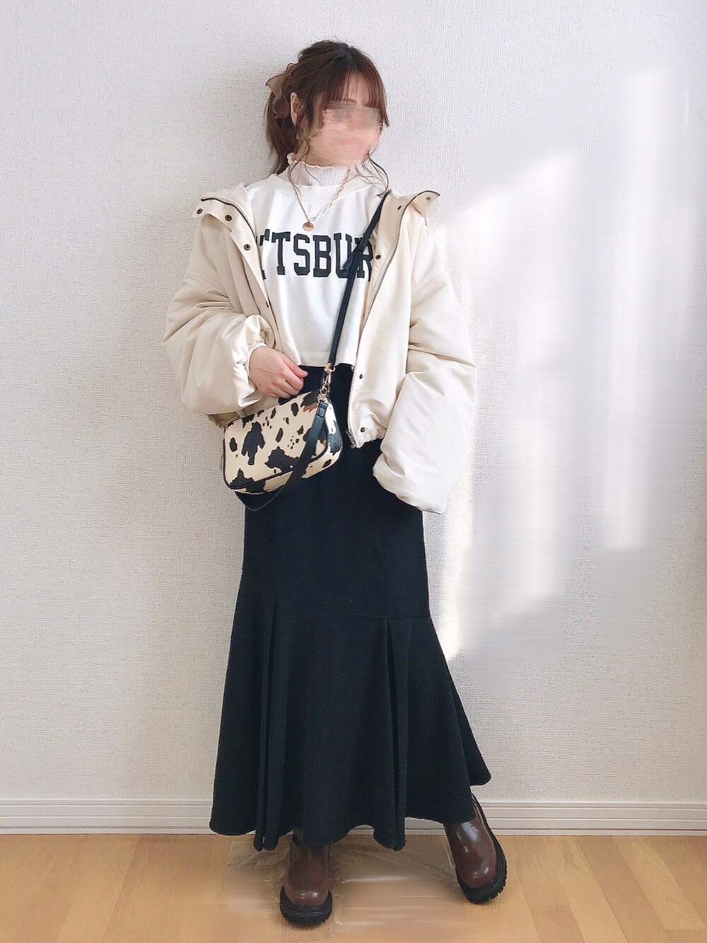ホワイト系のスウェット、ブラック系のスカート、ホワイト系のブルゾンを着用したレディースの冬コーディネートの2枚目の写真