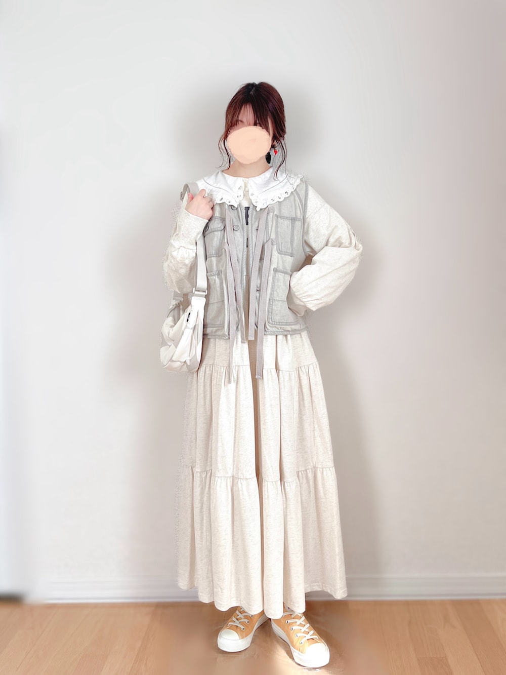 グレー系のベスト、ベージュ系のワンピース、ホワイト系のシャツ/ブラウスを着用したレディースの春コーディネートの3枚目の写真