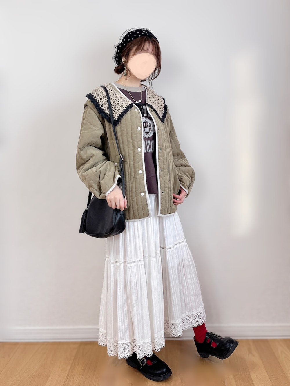 ブラウン系のTシャツ/カットソー、グリーン系のジャケット/アウター、ホワイト系のスカートを着用したレディースの冬コーディネートの2枚目の写真