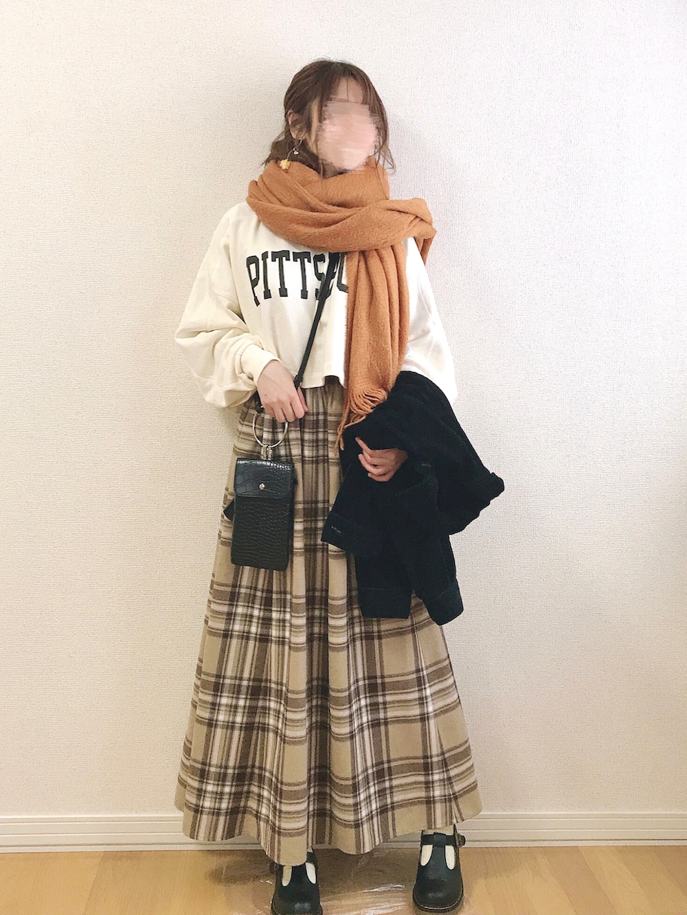 ホワイト系のスウェット、ベージュ系のスカート、ブラック系のその他アウターを着用したレディースの冬コーディネートの2枚目の写真