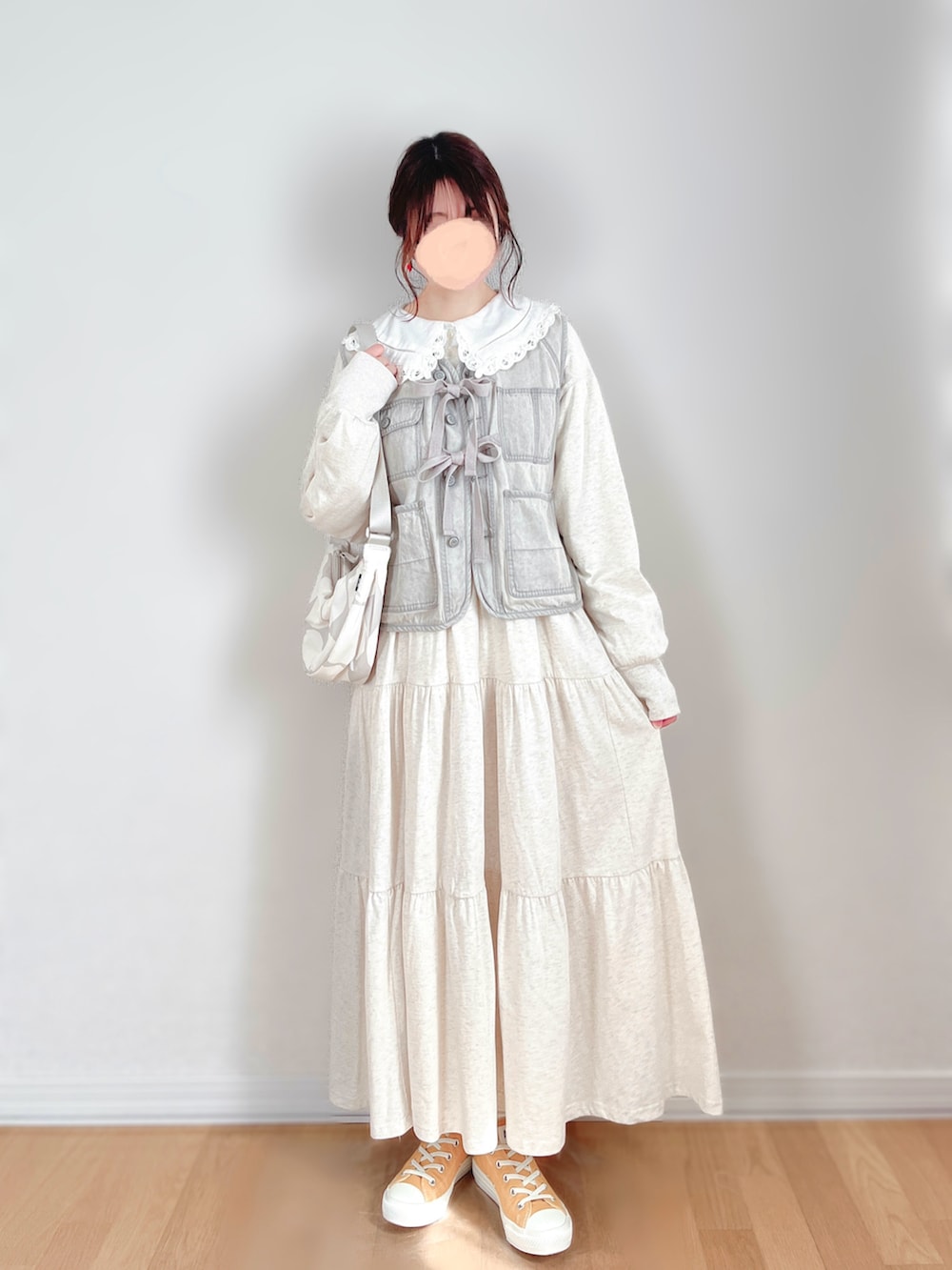 グレー系のベスト、ベージュ系のワンピース、ホワイト系のシャツ/ブラウスを着用したレディースの春コーディネートの2枚目の写真