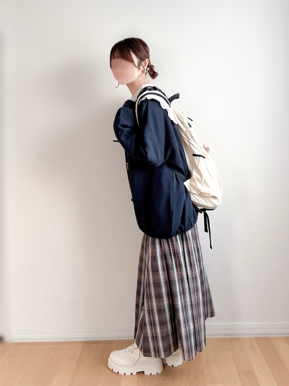 ホワイト系のシャツ/ブラウス、ホワイト系のブーツ、ベージュ系のバックパック/リュックを着用したレディースの冬コーディネートの4枚目の写真