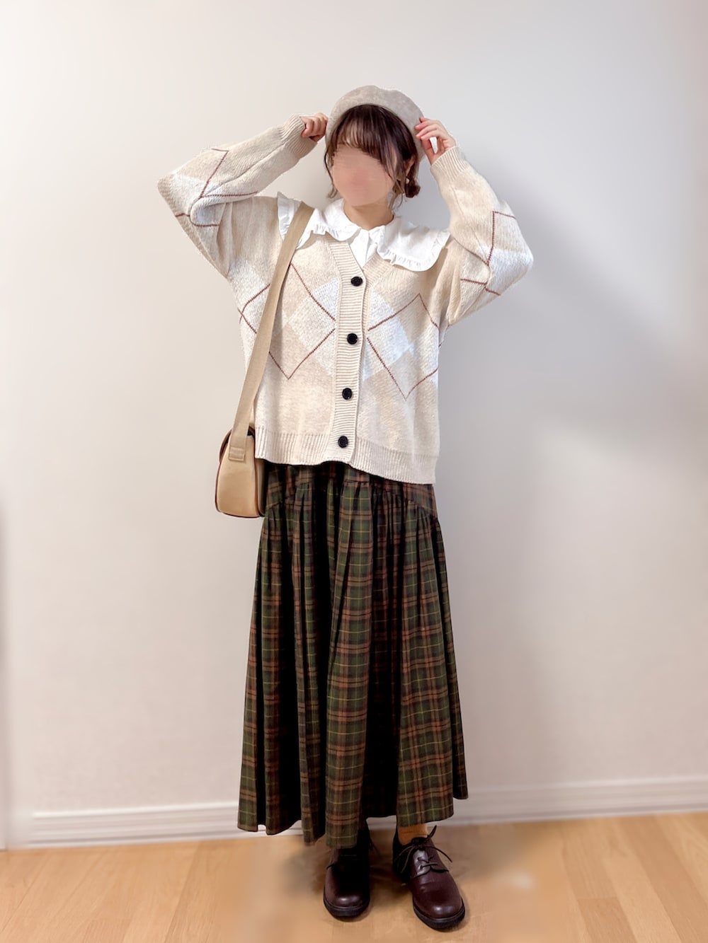 ベージュ系のカーディガン/ボレロ、ホワイト系のシャツ/ブラウス、ブラウン系のスカートを着用したレディースの秋コーディネートの3枚目の写真
