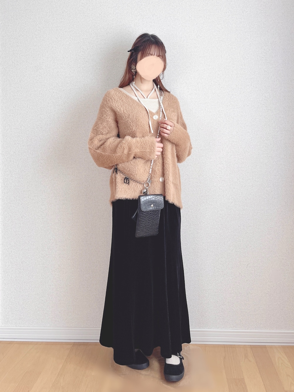 ベージュ系のTシャツ/カットソー、オレンジ系のカーディガン/ボレロ、ブラック系のスカートを着用したレディースの冬コーディネートの2枚目の写真