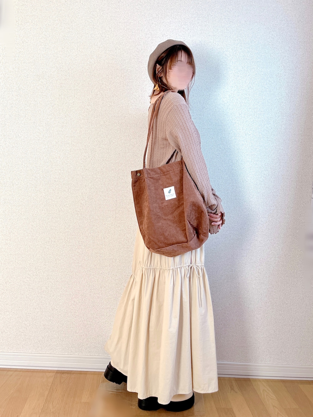 ブラウン系のカーディガン/ボレロ、ホワイト系のスカート、ブラウン系のトートバッグを着用したレディースの秋コーディネートの3枚目の写真