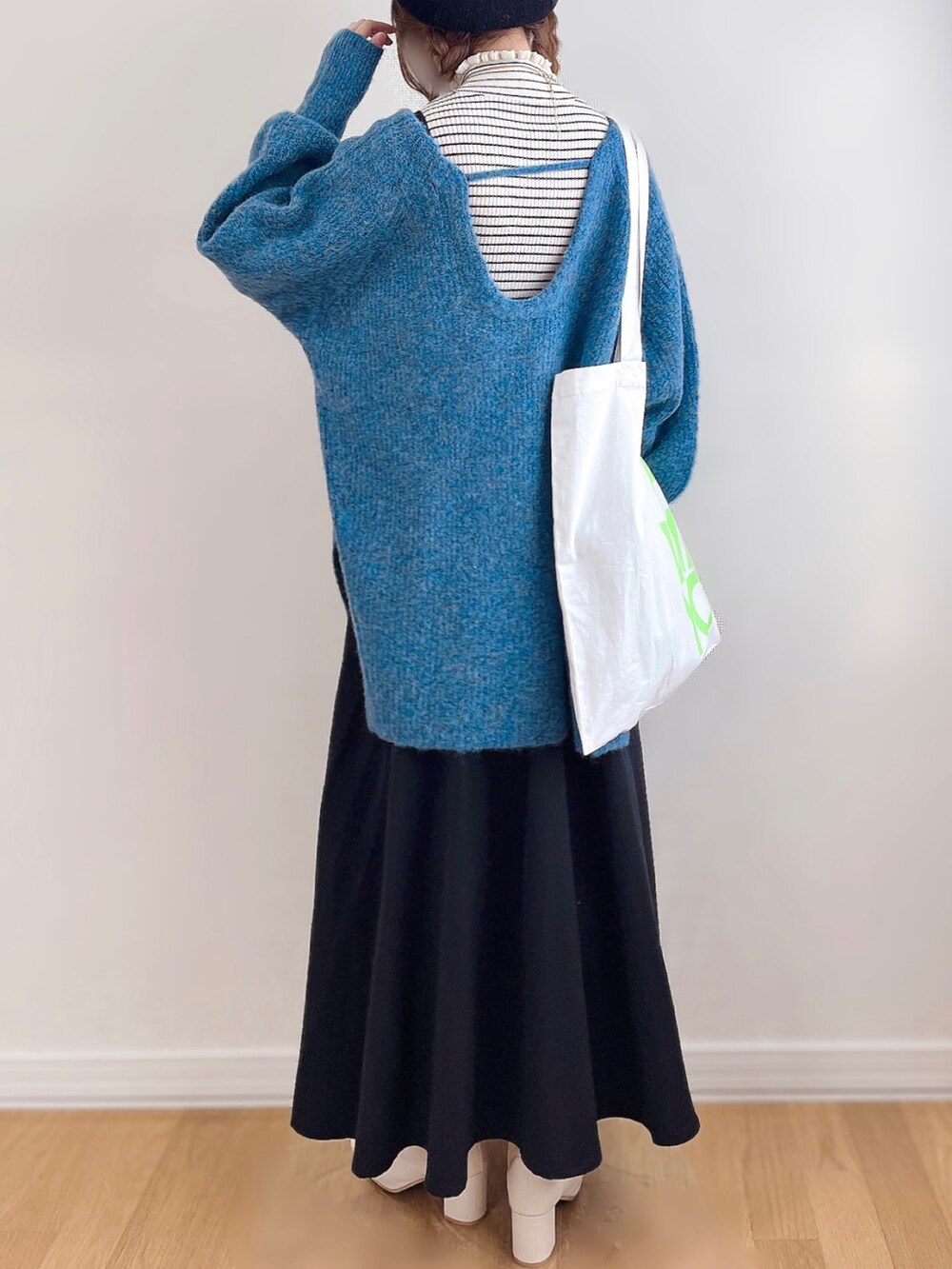 ブルー系のニット/セーター、ホワイト系のニット/セーター、ブラック系のワンピースを着用したレディースの冬コーディネートの5枚目の写真