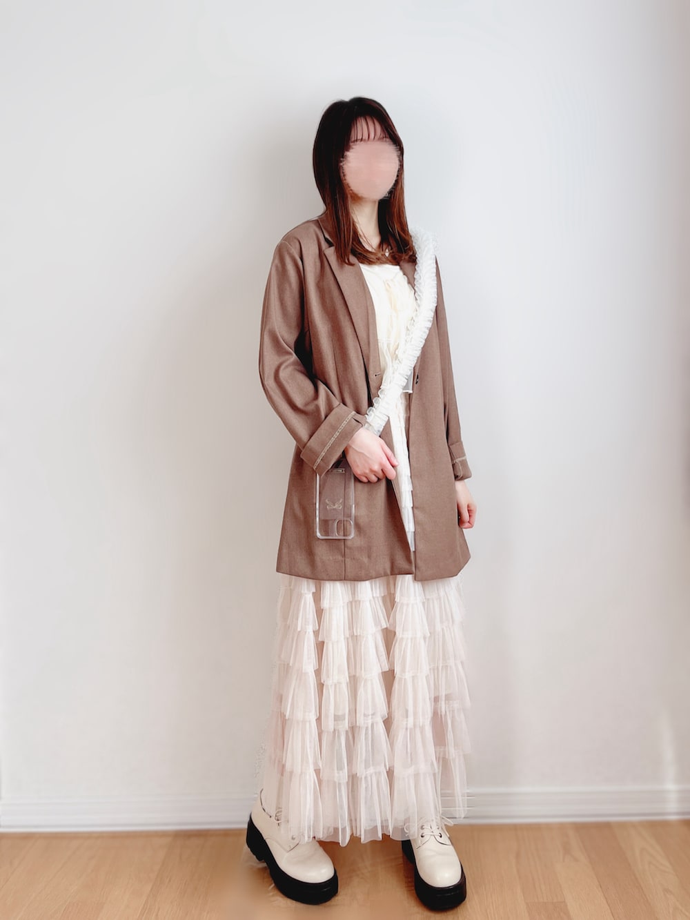 ブラウン系のテーラードジャケット、ホワイト系のキャミソール、ホワイト系のキャミソールを着用したレディースの春コーディネートの2枚目の写真