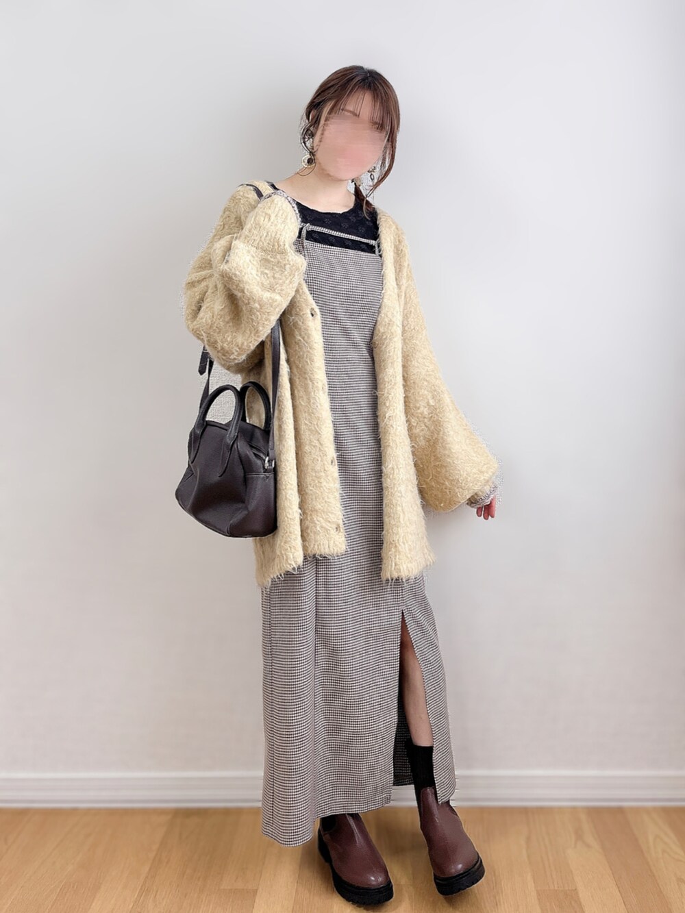 イエロー系のカーディガン/ボレロ、ブラウン系のワンピース、ブラック系のTシャツ/カットソーを着用したレディースの冬コーディネートの4枚目の写真