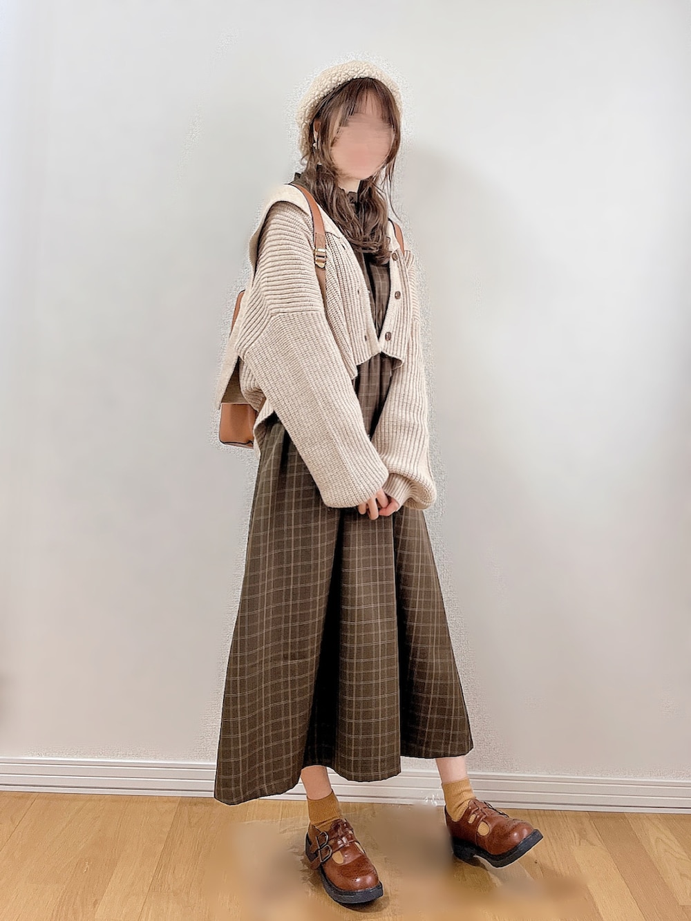 グリーン系のワンピース、ベージュ系のカーディガン/ボレロ、イエロー系のバックパック/リュックを着用したレディースの冬コーディネートの2枚目の写真