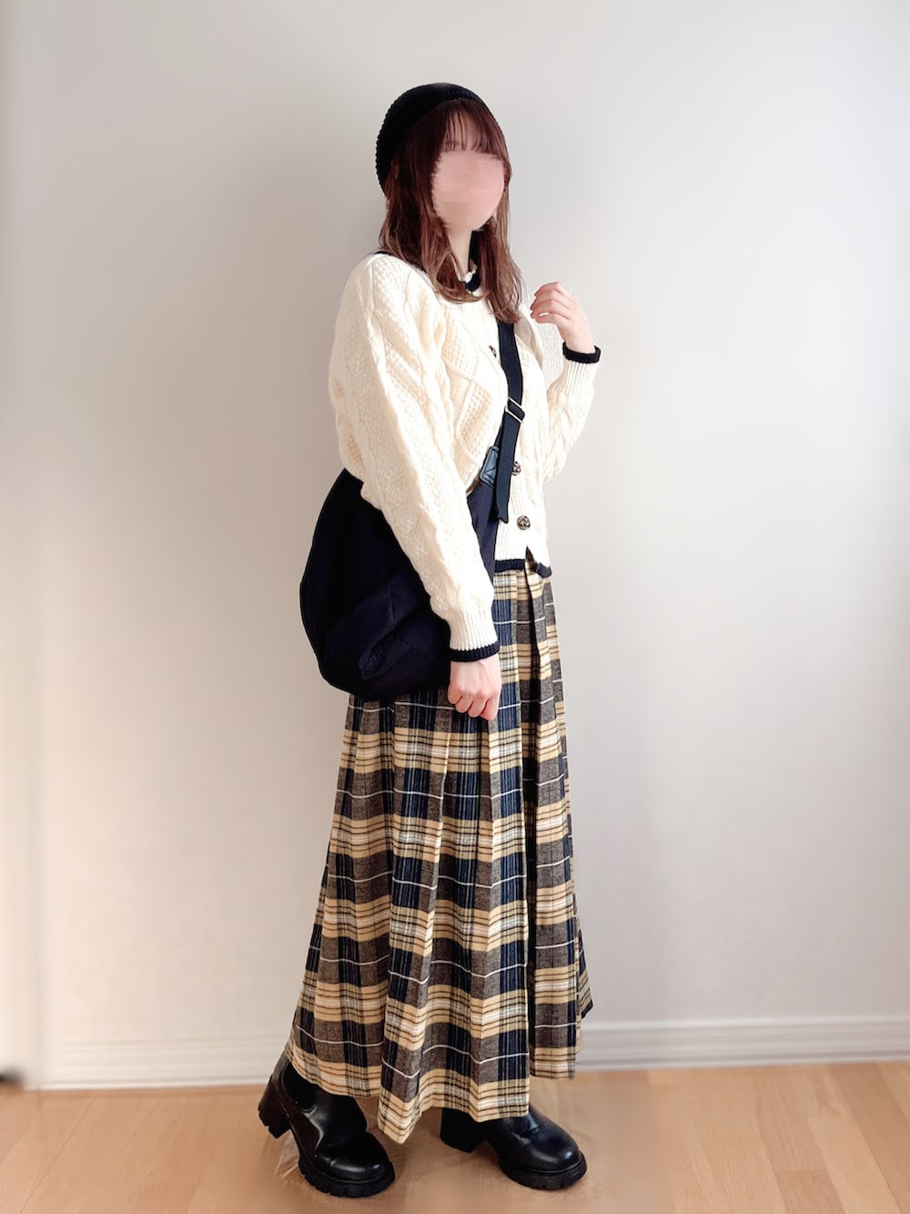 ホワイト系のカーディガン/ボレロ、イエロー系のスカート、ブラック系のブーツを着用したレディースの秋コーディネートの3枚目の写真