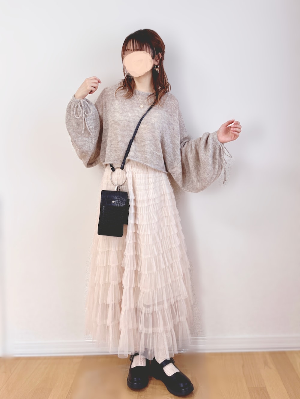 グレー系のニット/セーター、ホワイト系のスカート、ブラック系のショルダーバッグを着用したレディースの秋コーディネートの2枚目の写真