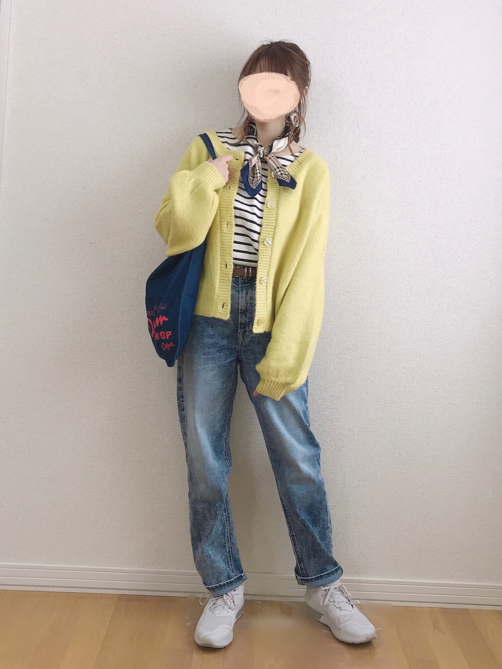 イエロー系のカーディガン/ボレロ、ホワイト系のTシャツ/カットソー、ブルー系のデニムパンツを着用したレディースの春コーディネートの2枚目の写真