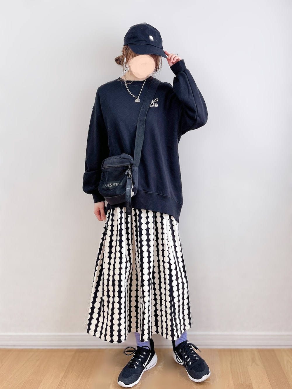 ブルー系のスウェット、ブラック系のスカート、ブラック系のスニーカーを着用したレディースの春コーディネートの2枚目の写真