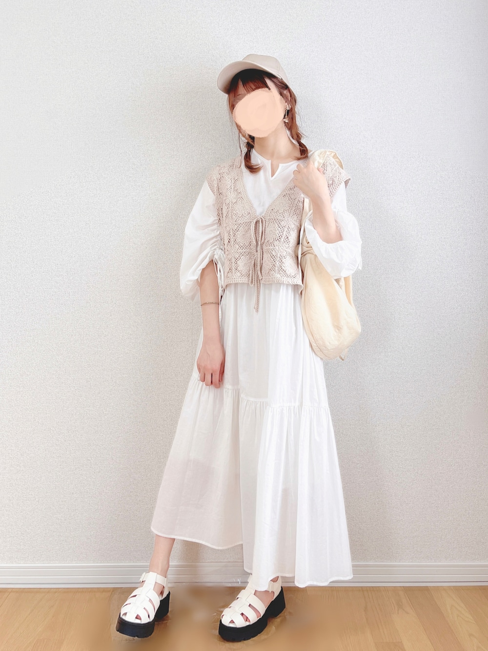ホワイト系のワンピース、ベージュ系のベスト、ホワイト系のショルダーバッグを着用したレディースの夏コーディネートの4枚目の写真