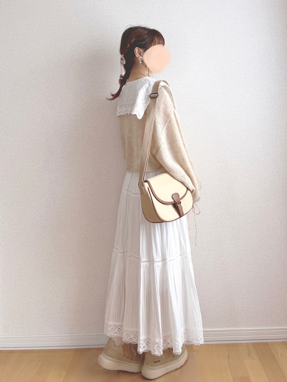 ベージュ系のニット/セーター、ホワイト系のスカート、ベージュ系のショルダーバッグを着用したレディースの秋コーディネートの4枚目の写真