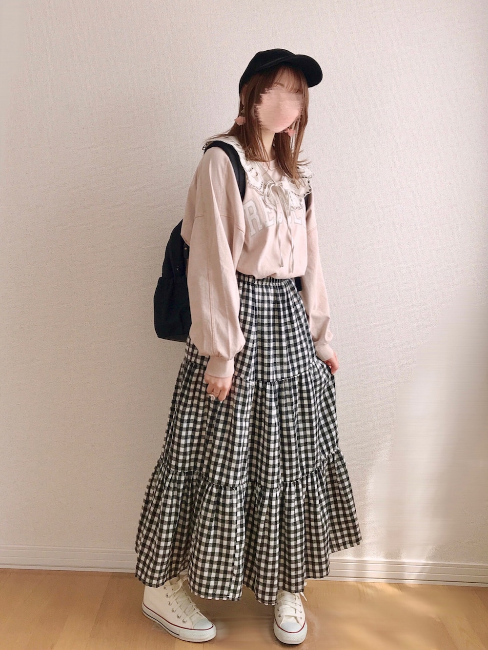 ピンク系のスウェット、ベージュ系のスカート、ホワイト系のスニーカーを着用したレディースの春コーディネートの2枚目の写真