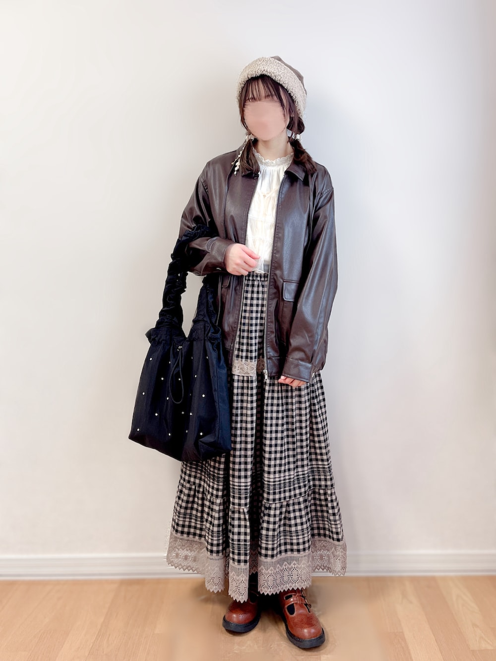 ブラウン系のブルゾン、ホワイト系のキャミソール、ブラック系のトートバッグを着用したレディースの冬コーディネートの2枚目の写真