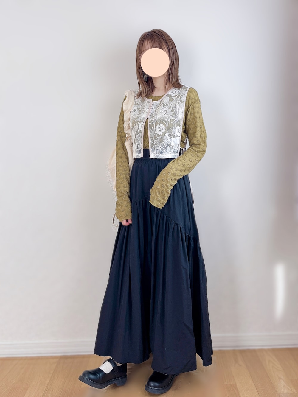 ホワイト系のベスト、グリーン系のTシャツ/カットソー、ブラック系のスカートを着用したレディースの春コーディネートの2枚目の写真