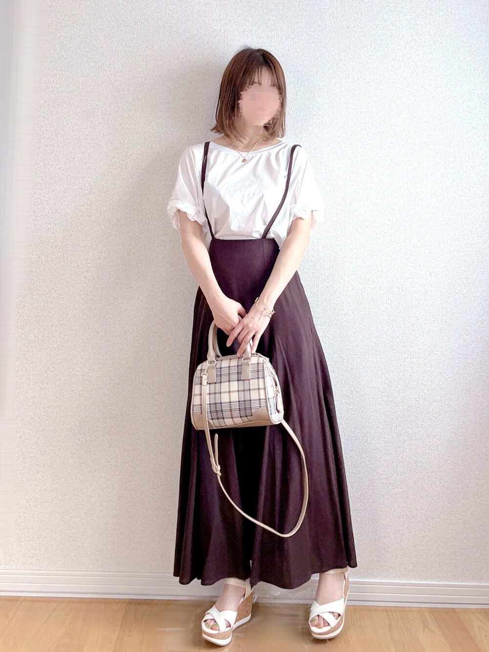 ホワイト系のTシャツ/カットソー、イエロー系のスカート、ブラック系のショルダーバッグを着用したレディースの夏コーディネートの2枚目の写真