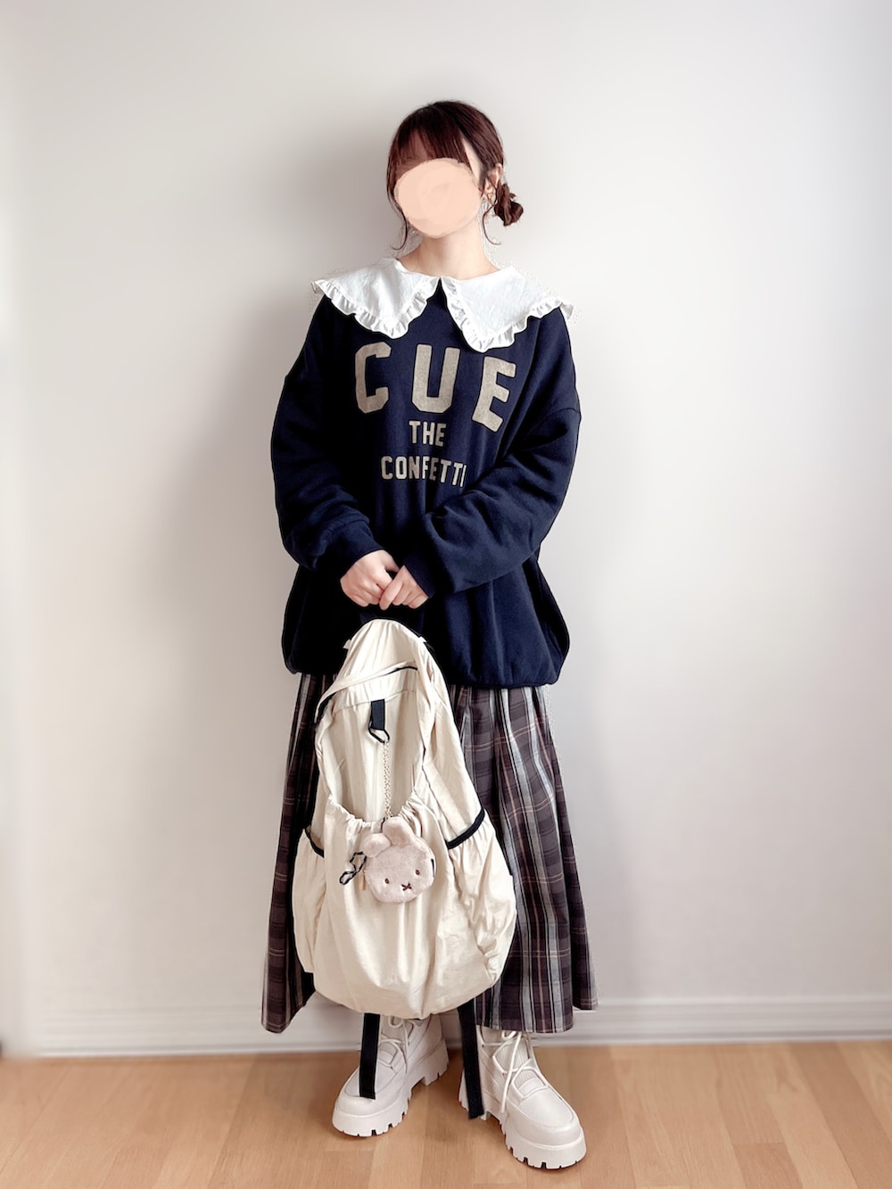 ホワイト系のシャツ/ブラウス、ホワイト系のブーツ、ベージュ系のバックパック/リュックを着用したレディースの冬コーディネートの2枚目の写真