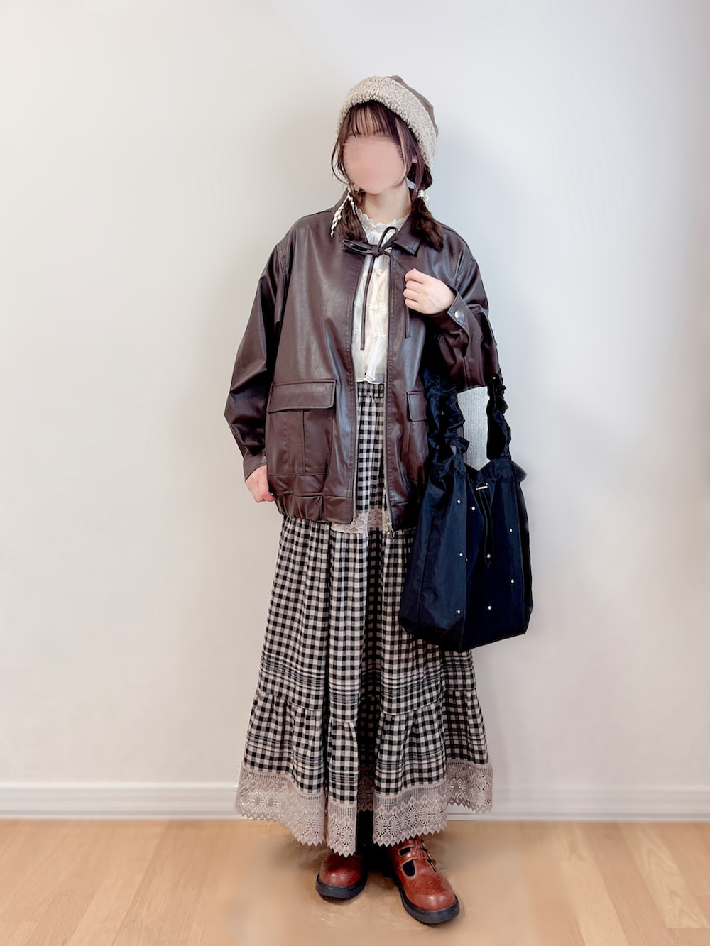 ブラウン系のブルゾン、ホワイト系のキャミソール、ブラック系のトートバッグを着用したレディースの冬コーディネートの4枚目の写真