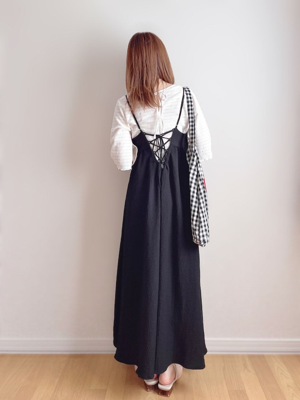 ブラック系のワンピース、ブラック系のトートバッグ、ベージュ系のサンダルを着用したレディースの夏コーディネートの4枚目の写真