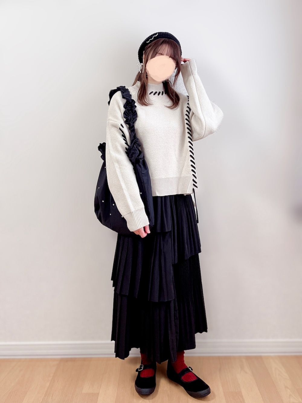 ベージュ系のニット/セーター、ブラック系のスカート、ブラック系のトートバッグを着用したレディースの春コーディネートの4枚目の写真