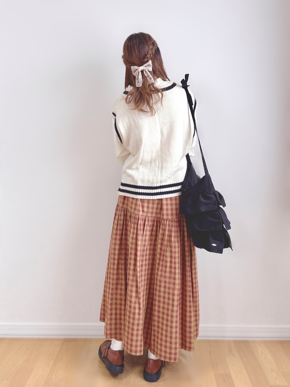 ホワイト系のシャツ/ブラウス、ホワイト系のベスト、ブラック系のトートバッグを着用したレディースの秋コーディネートの3枚目の写真