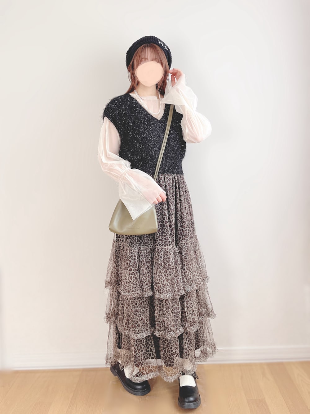 ブラック系のベスト、ホワイト系のTシャツ/カットソー、ベージュ系のスカートを着用したレディースの秋コーディネートの2枚目の写真