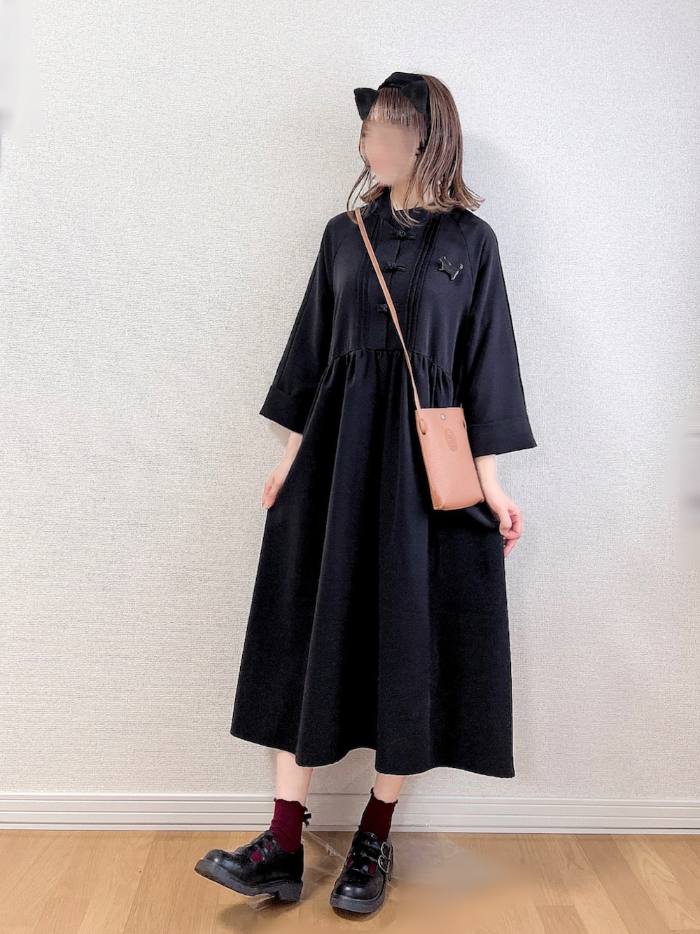 ブラック系のワンピース、ブラック系のドレスシューズ、ブラウン系のバッグを着用したレディースの秋コーディネートの2枚目の写真