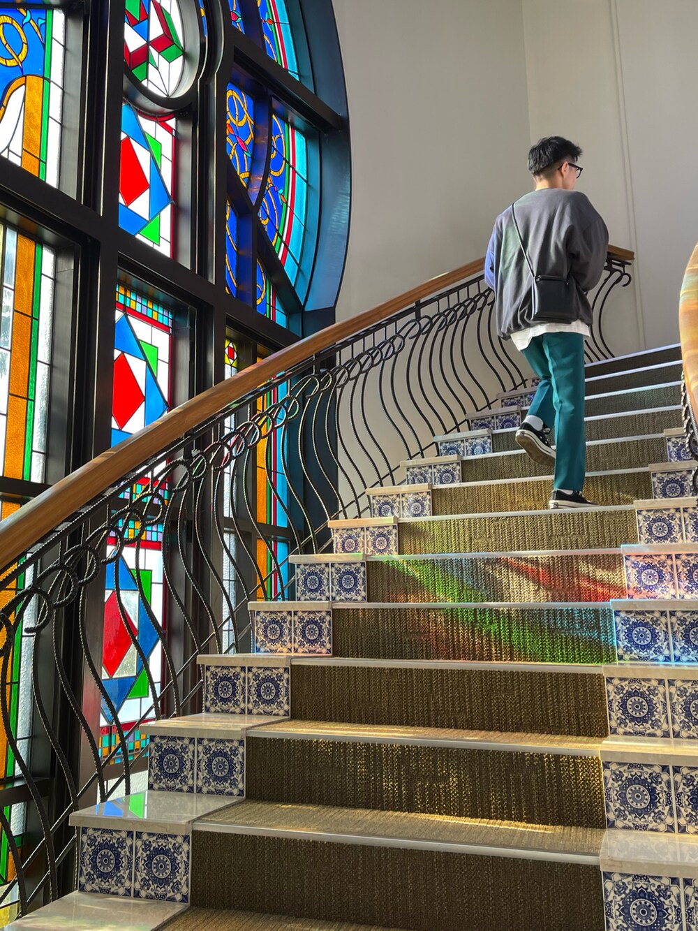 グリーン系のスラックス、ブラック系のスウェット、ブラック系のスニーカーを着用したメンズの秋コーディネートの3枚目の写真