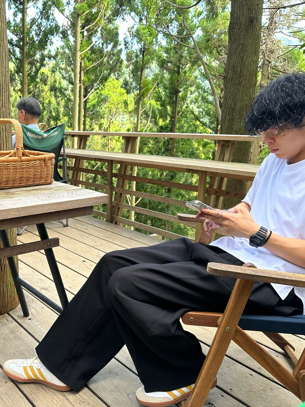 ブラック系のTシャツ/カットソー、ブラック系のスラックス、イエロー系のスニーカーを着用したメンズの秋コーディネートの3枚目の写真