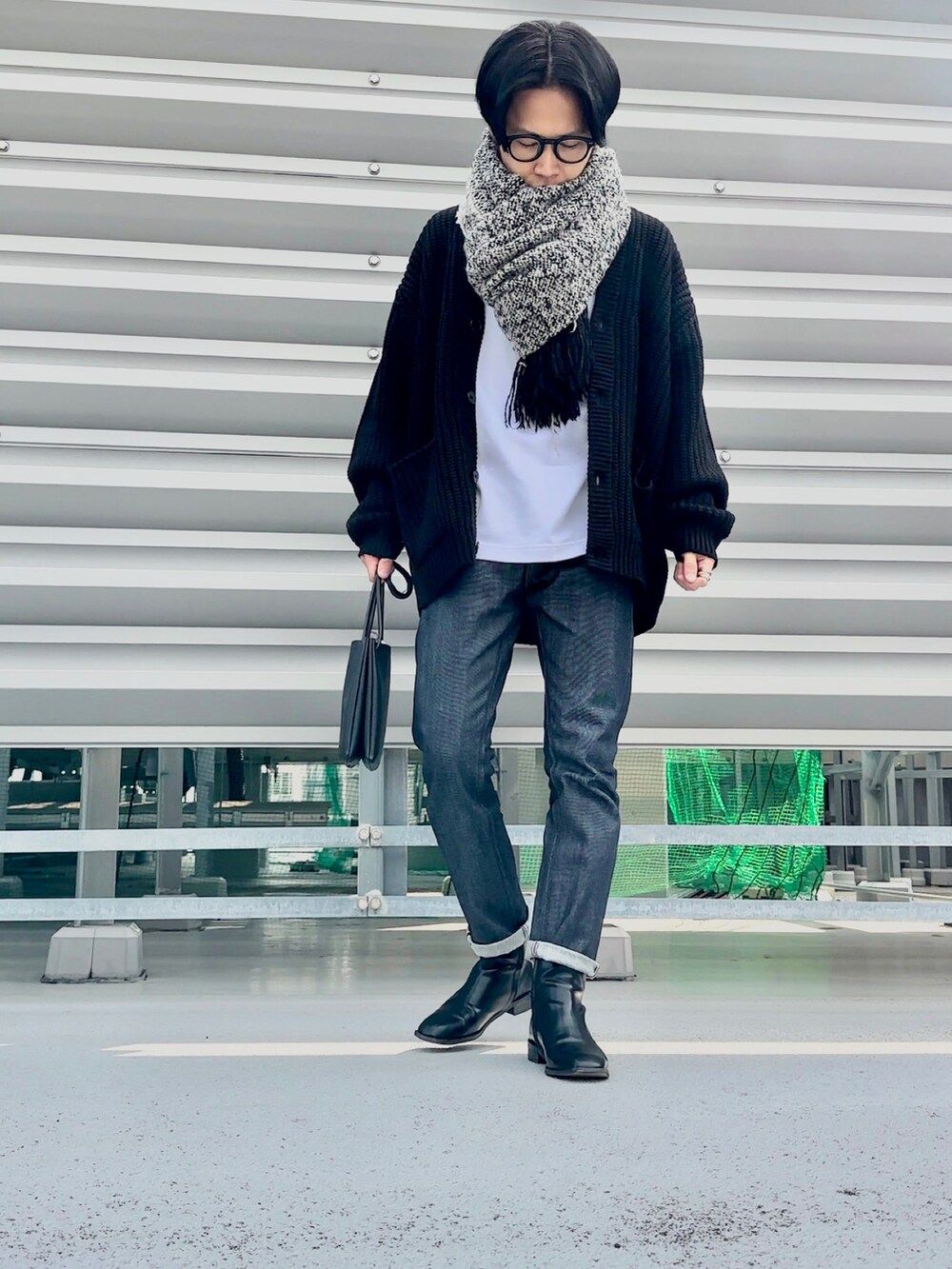 ブラック系のカーディガン/ボレロ、ブルー系のデニムパンツ、ブラック系のブーツを着用したメンズの冬コーディネートの2枚目の写真