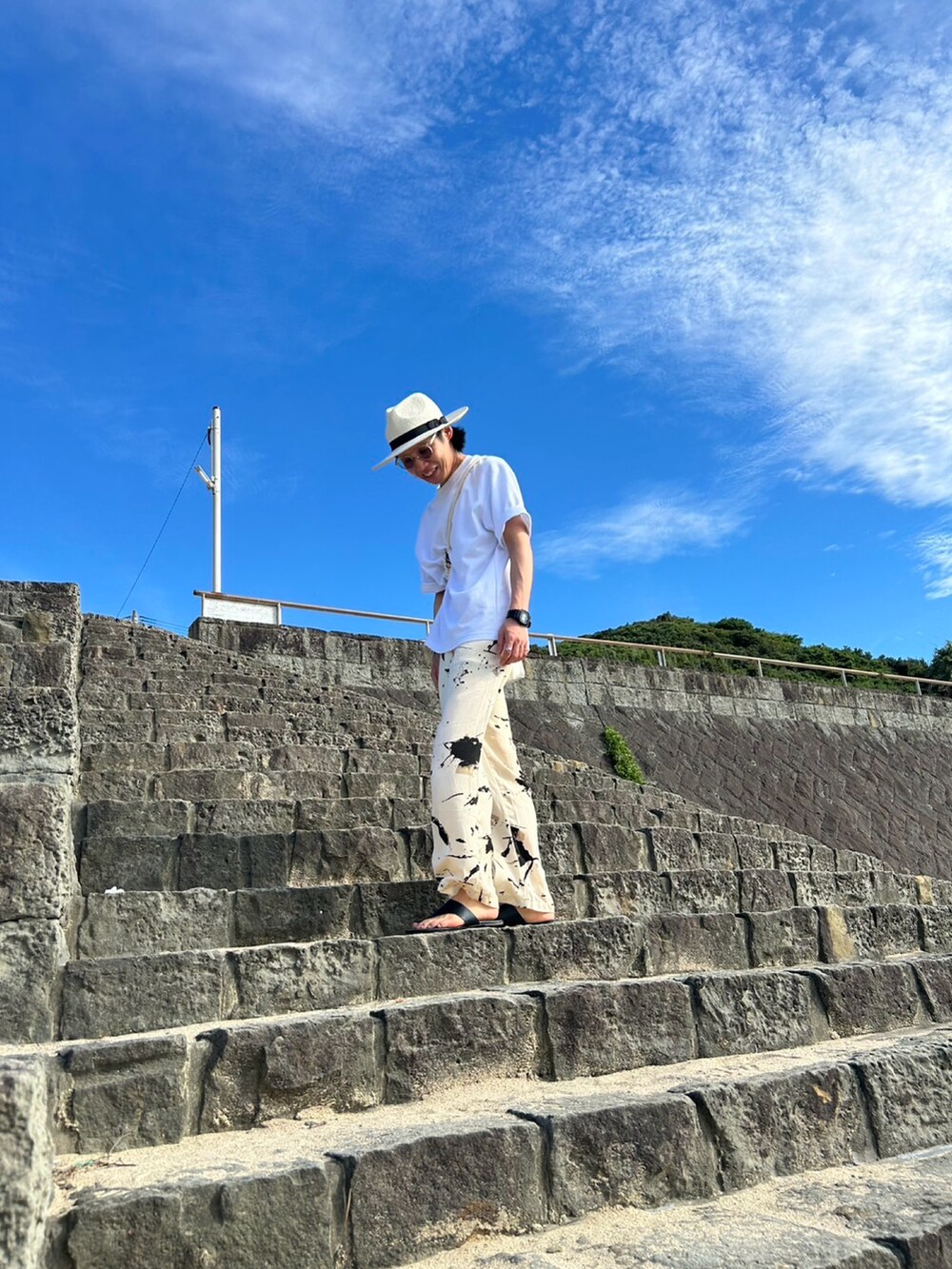 ベージュ系のその他パンツ、ホワイト系のTシャツ/カットソー、ホワイト系のハットを着用したメンズの夏コーディネートの2枚目の写真