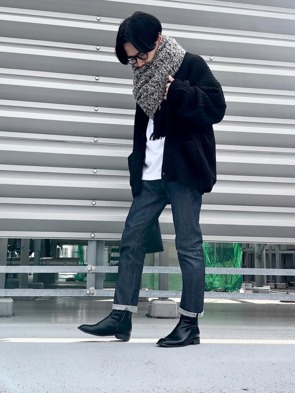 ブラック系のカーディガン/ボレロ、ブルー系のデニムパンツ、ブラック系のブーツを着用したメンズの冬コーディネートの3枚目の写真