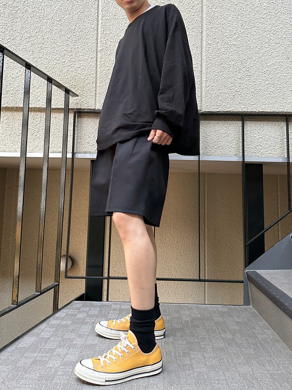 ブラック系のTシャツ/カットソー、ブラック系のその他パンツ、その他のスニーカーを着用したメンズの春コーディネートの4枚目の写真